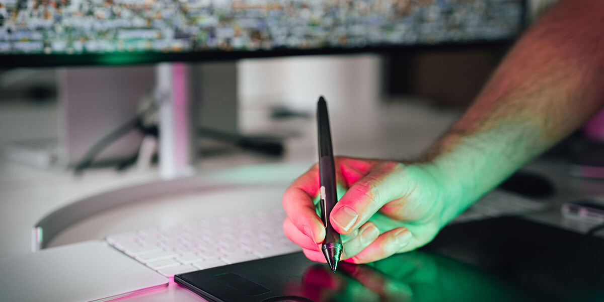 A graphic designer draws on a tablet in front of a computer monitor. 3D rendering, design studio, 3D product, animation, character design, 2D animation, video production services, book trailer services, digital marketing services, motion design, motion graphics. RDV Media – Multimedia production company. Serving brands globally. New York, Los Angeles, California, Atlanta, USA, Dublin, Ireland, EU, London, England, UK, Doha, Qatar, UAE, Abu Dhabi, Ajman, Dubai, Fujairah, Ras Al Khaimah, Sharjah, and Umm Al Quwain.