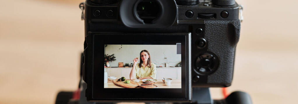 A woman sits at a kitchen table with food, viewed through the screen of a digital camera during a cooking demonstration or vlog recording. 3D rendering, design studio, 3D product, animation, character design, 2D animation, video production services, book trailer services, digital marketing services, motion design, motion graphics. RDV Media – Multimedia production company. Serving brands globally. New York, Los Angeles, California, Atlanta, USA, Dublin, Ireland, EU, London, England, UK, Doha, Qatar, UAE, Abu Dhabi, Ajman, Dubai, Fujairah, Ras Al Khaimah, Sharjah, and Umm Al Quwain.