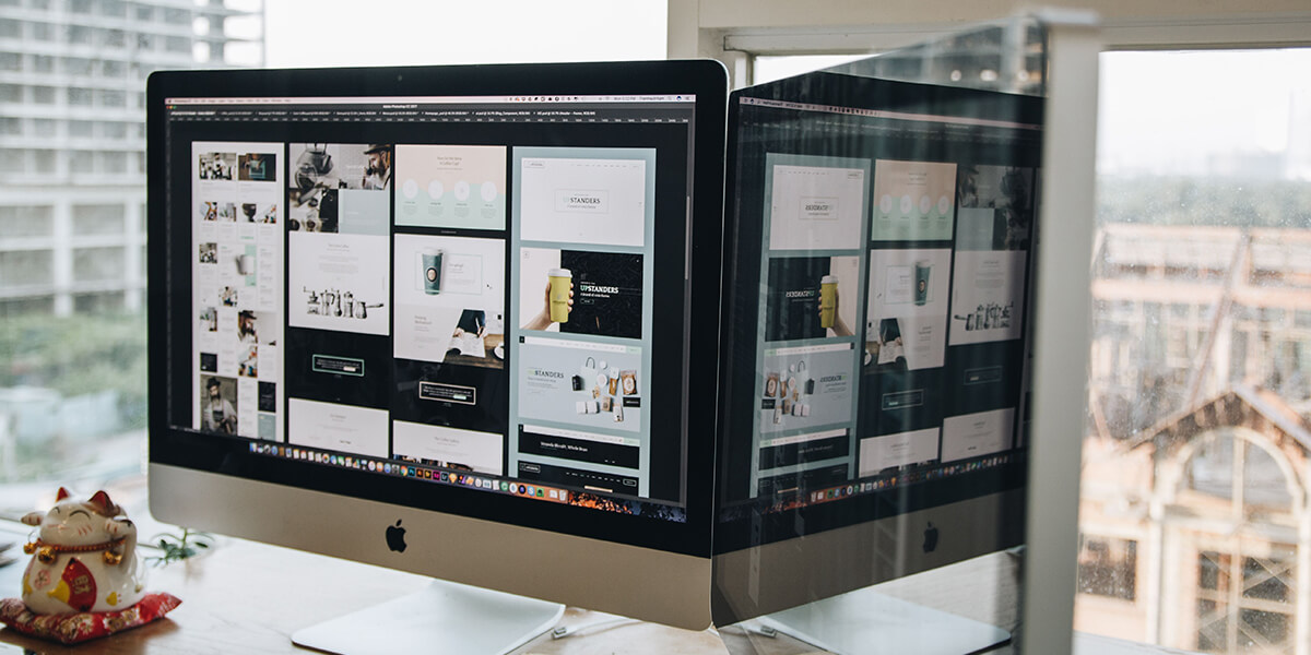 A computer monitor displaying various website designs on a white desk, reflecting a digital workspace setup. RDV Media – multimedia production and marketing company. Serving brands globally.